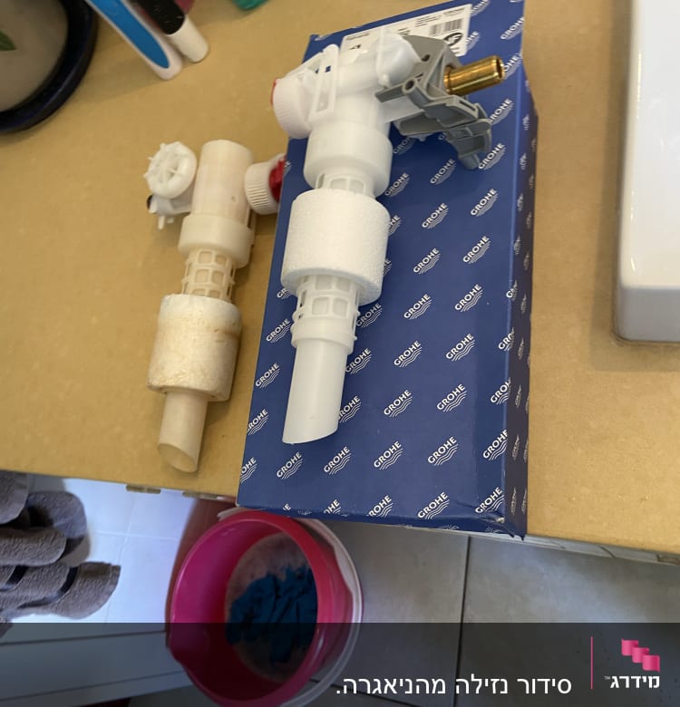 חלקי אינסטלציה על קופסת גרואה במטבח